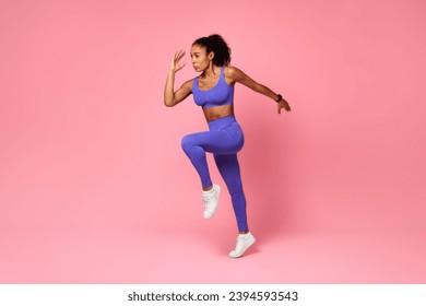 Athletic African American Lady In Fitwear Jumping Exercising During Training Over Pink Studio Background, Full Length, Side View Shot. Sport Motivation And Fitness Workout Concept - Powered by Shutterstock