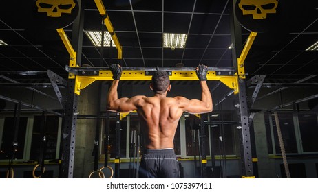 Athletic African American Man Does Pull-ups In Gym. Power Pull Up Workout. How Looks Muscles During Pulling.