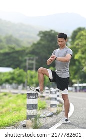 Athletic Asian Man Resting And Checking Heart Rate Data On Smartwatch During Workout