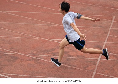 Athletic Asian Runner Sprinter Crossing The Finish Line.