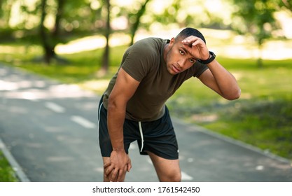 Athletic black guy feeling tired after his morning run at urban park, panorama