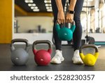 Athletic bodybuilding sport woman squat with kettlebell fitness training at gym. Beautiful sportive fit female workout with heavy equipment back and butts buttons muscle physical exercise