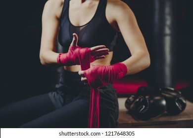 Athletic Boxer Female Wraps Bandages On Her Hands Puts Gloves For Fight In Gym