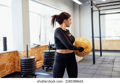 Athletic brunette girl working out in gym. Fitness woman training with medicine ball - Shutterstock ID 2185388665
