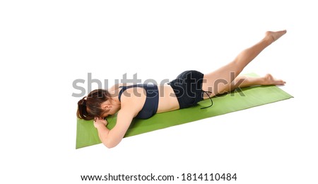 athletic brunette lies face down on a sports mat. does exercise to stretch his legs. A girl in sportswear puts her hands under her head and stretches her leg, bending and unbending her feet.