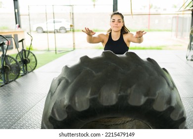 Athletic Caucasian Woman Working Out With A Cross Training Routine And Doing Tire Flip Exercises