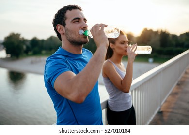 Athletic Couple Drinking Water After Running