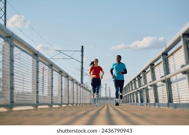 Athletic couple jogging while having sports training outdoors. Copy space.  - Powered by Shutterstock
