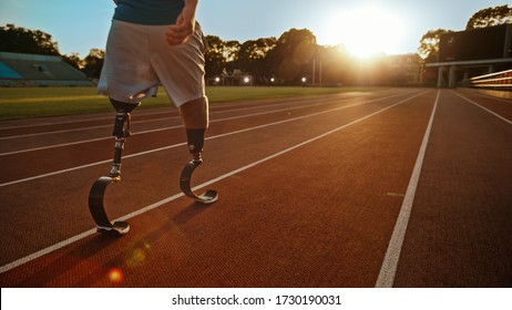 Athletic Disabled Fit Man with Prosthetic Running Blades is Walking During a Training on an Outdoor Stadium on a Sunny Afternoon. Amputee Runner Preparing for a Run. Motivational Sports Shot. - Powered by Shutterstock