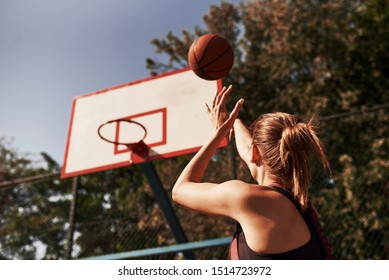 Athletic female basketball player throwing a ball up to the net. - Powered by Shutterstock