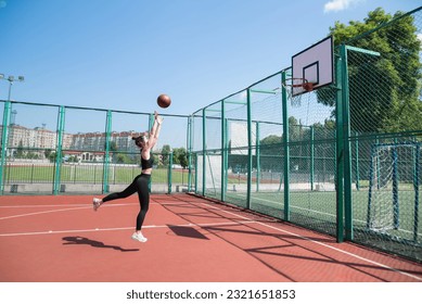 Athletic female basketball player throwing a ball up to the net. - Powered by Shutterstock