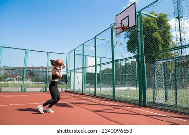 Athletic female basketball player throwing a ball up to the net. - Powered by Shutterstock