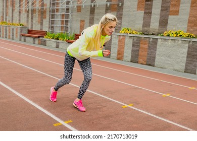 Athletic Female Model At An Outdoor Stadium. Running Technique Training Outside