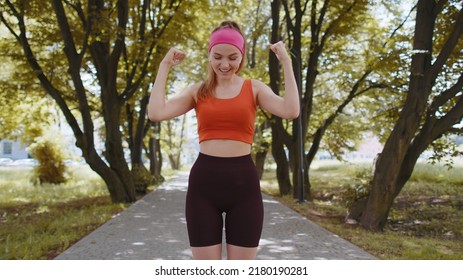 Athletic fit runner girl celebrate success win scream rejoices triumph victory marathon race. Workout cardio training in sunny park. Young woman enjoy healthy lifestyle. Active sportswoman motivation