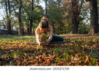 Athletic fit woman stretching legs before workout in city park. Pilates, yoga stretching before running. Pilates training outdoor in city park. - Powered by Shutterstock