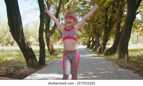 Athletic Fitness Sport Runner Child Girl Finishing Racing Competition, Victory. Celebrating, Dancing. Workout Cardio Training In Park. Toddler Kid Jogger Champion Winning Marathon. Children Motivation