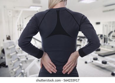 Athletic Fitness Woman Suffering From Lower Back Pain In Gym. Sports Exercising Injury.