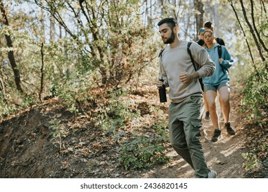 Athletic friends hiking in scenic mountains, enjoying a sunny day in the wilderness. Conversations flow as they explore the natural environment, embracing an active and healthy lifestyle. - Powered by Shutterstock