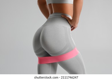 Athletic girl doing exercise for glutes with resistance band. Beautiful butt, fitness woman working out