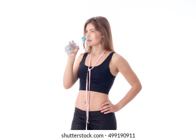 Athletic Girl Holding A Bottle And Going To Drink Some Water And Put Her Other Hand On The Side Turned Sideways And Looking Away