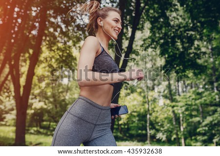 athletic girl running in the Park and doing exercises Jogging