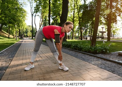 Athletic Girl In Sport Tight Clothes Doing Stretching After The Early Morning Jog. Middle Aged Active Woman, Athlete In Sportswear Exercising Outdoor.