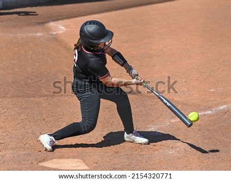 Athletic girls in action playing in a softball game