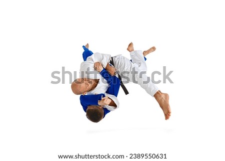 Athletic male sportsmen, martial arts fighters fighting performing techniques in motion, action isolated white background. Concept of martial art, combat sport, health, strength, energy. Copy space