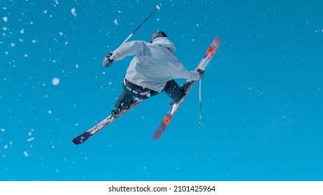 Athletic male tourist rides off a big snowpark kicker in Vogel and does a spectacular 360 grab. Expert freestyle skier rides up a kicker and does an awesome spinning trick on a sunny winter day.