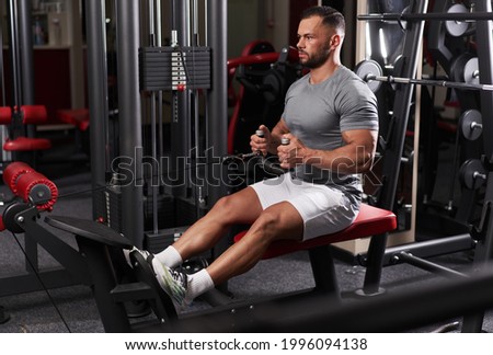 Athletic man doing back workout at cable row machine