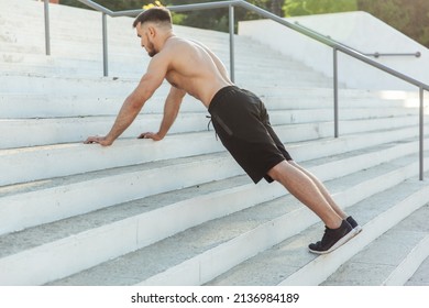 Athletic man doing push-ups on the stairs outdoors
