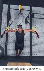 Athletic Man Exercising With Trx Gym Equipment