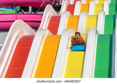 Athletic Man Is Having Fun Going Down A Water Slide