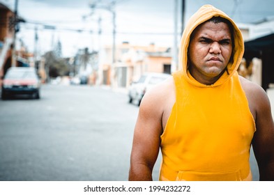 Athletic Man Of Latin Origin After Training With A Tough Attitude With A Yellow Sweater Or Walks With A Hood And A Bad Man's Face, Dominican Model In Sport