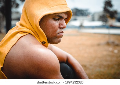 Athletic Man Of Latin Origin After Training With A Tough Attitude With A Yellow Sweater Or Walks With A Hood And A Bad Man's Face, Dominican Model In Sport