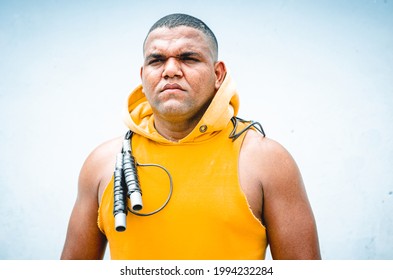 Athletic Man Of Latino Origin After Training With A Tough Attitude With A Yellow Sweater Or Walks With A Hood And A Bad Man's Face, Dominican Model In Sport With Jump Rope