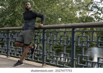 Athletic man leaning on footbridge in park - Powered by Shutterstock