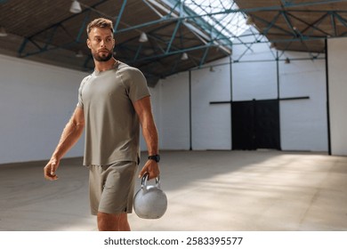 Athletic man preparing for a workout while he is holding a weight at the fitness hangar