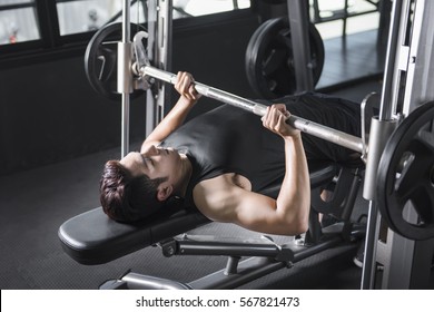 Athletic Man Pumping Up Muscles On Bench Press