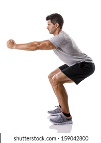 Athletic man running doing squats, isolated over a white background