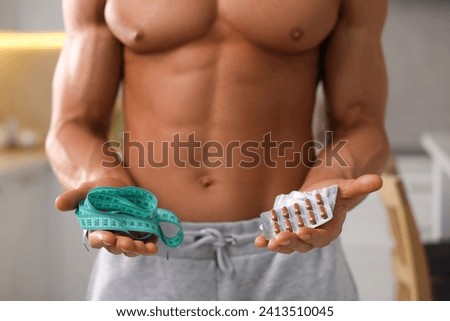 Athletic man with supplements and measuring tape indoors, closeup. Weight loss