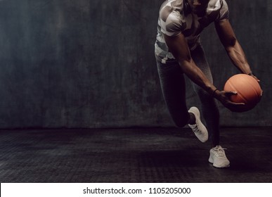 Athletic man training with a basketball. Man working out holding a basketball in hand. - Powered by Shutterstock