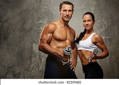 Athletic Man And Woman With A Dumbells.