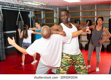 Athletic men doing strength techniques in self defense training