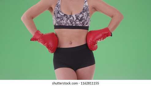 Athletic millennial woman posing with boxing gloves on green screen - Powered by Shutterstock