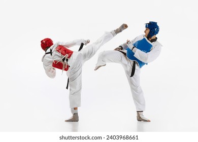 Athletic, motivated young men, taekwondo athletes in motion, practicing, training isolated over white background. Concept of martial arts, combat sport, competition, action, strength, education