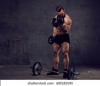Athletic muscular, bearded male doing biceps workouts with dumbbells. - Shutterstock ID 600183590