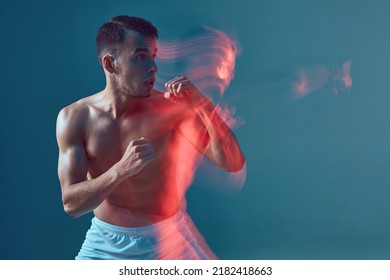 Athletic Muscular Guy Standing In Defense Stance With Clenched Fists. Boxing Workout. Neon Light, Motion Blur