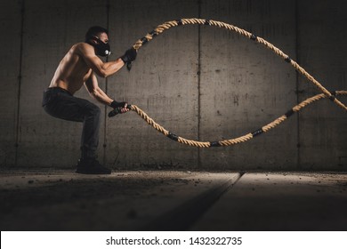 Athletic, Muscular Man Wearing Training Mask And Doing Battle Ropes Functional Training, Making Waves With The Ropes, Exercising Strength