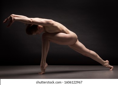 Athletic natural woman body on dark background. Nude woman Yoga.  